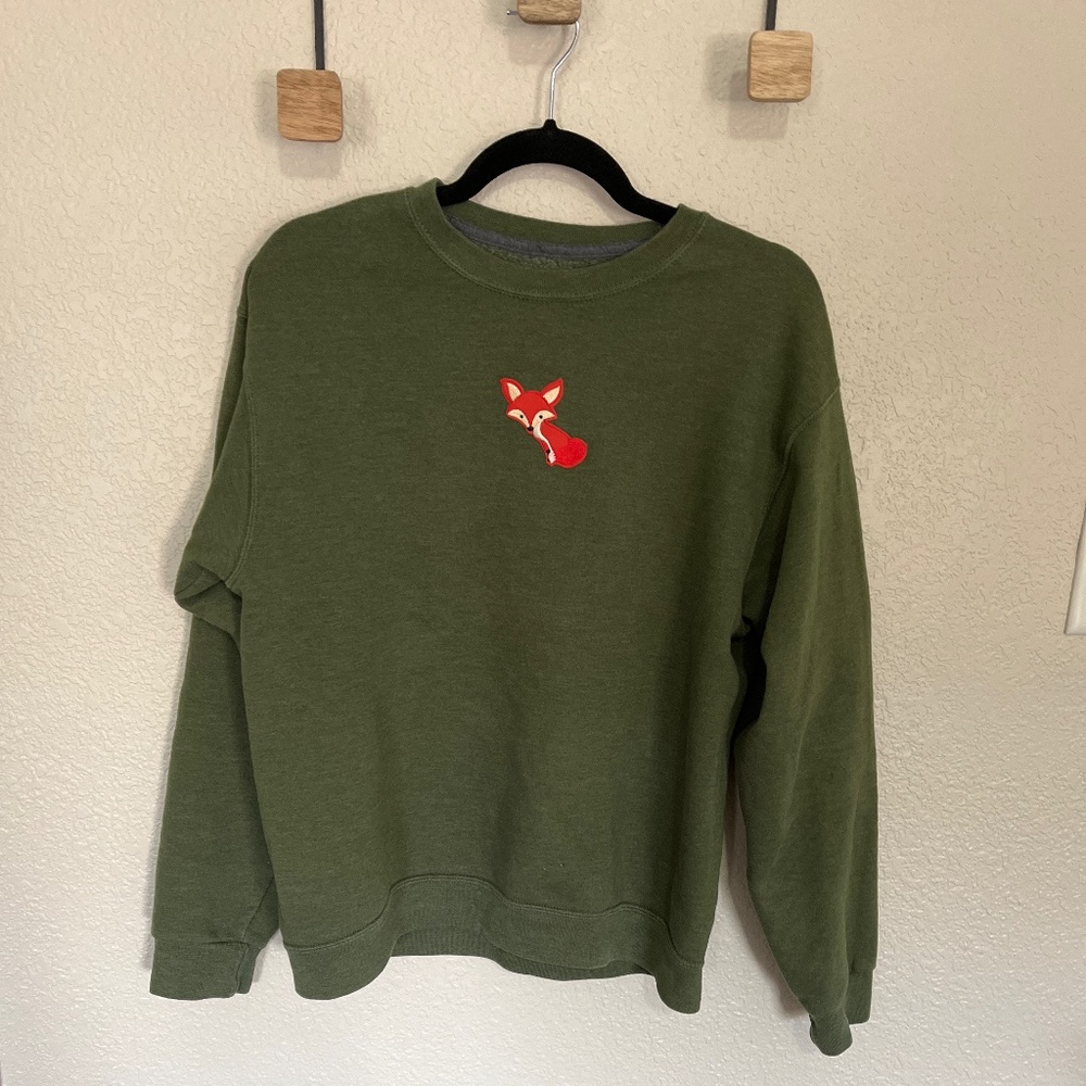Olive green sweatshirt with an orange fox decal